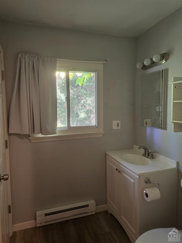 bathroom with vanity, toilet, wood-type flooring, and baseboard heating