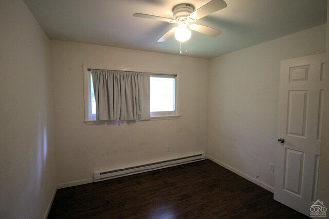 spare room featuring ceiling fan, dark hardwood / wood-style floors, and a baseboard heating unit