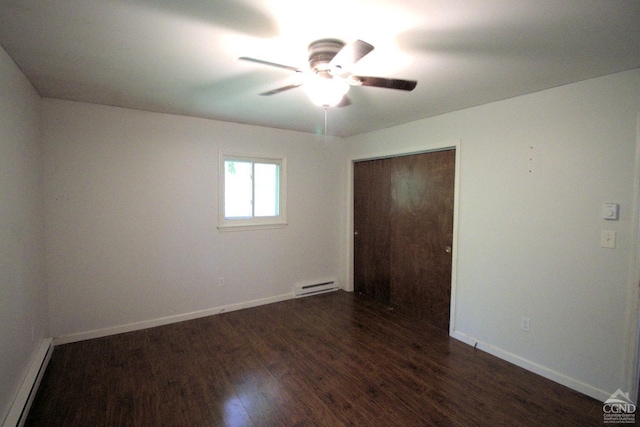 spare room featuring ceiling fan, dark wood-type flooring, and a baseboard heating unit