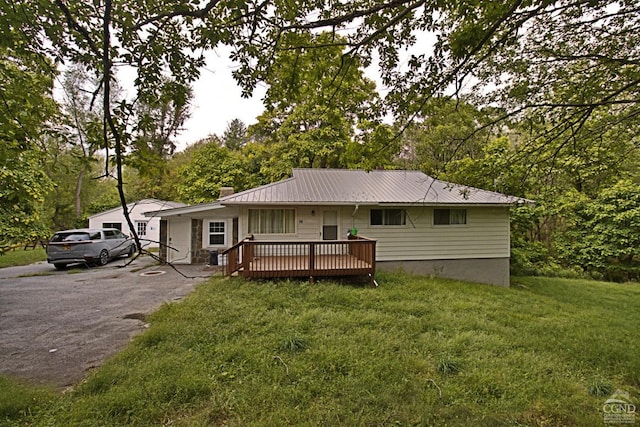 view of front of property featuring a wooden deck and a front lawn