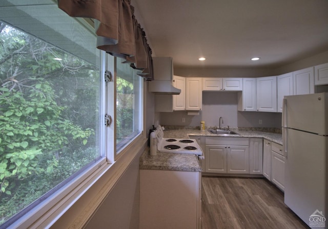 kitchen featuring white appliances, white cabinets, sink, range hood, and dark hardwood / wood-style flooring