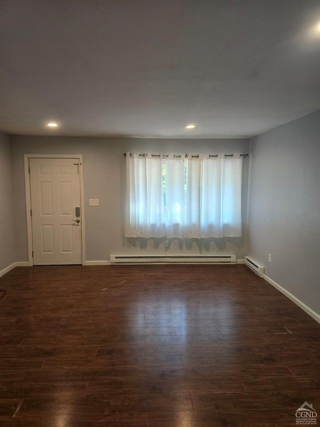 interior space featuring dark hardwood / wood-style flooring and a baseboard heating unit