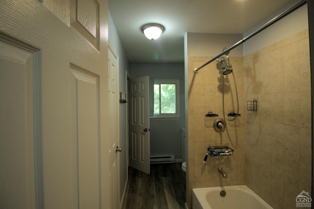 bathroom with toilet, hardwood / wood-style flooring, a baseboard radiator, and tiled shower / bath