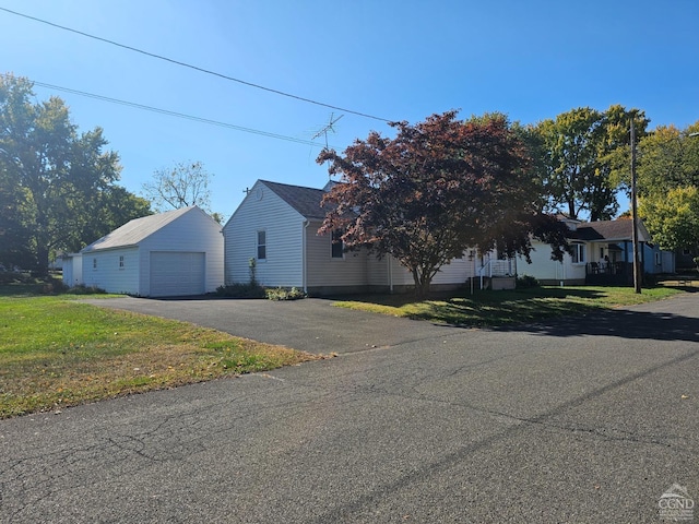 view of home's exterior featuring a lawn, an outbuilding, and a garage