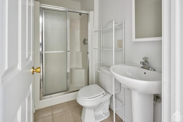 bathroom featuring tile patterned flooring, toilet, and walk in shower