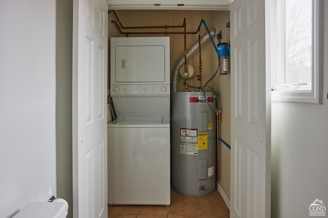 clothes washing area featuring water heater, stacked washer and dryer, and light tile patterned floors