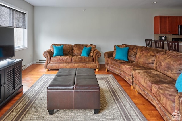 living room featuring baseboard heating and light wood-type flooring