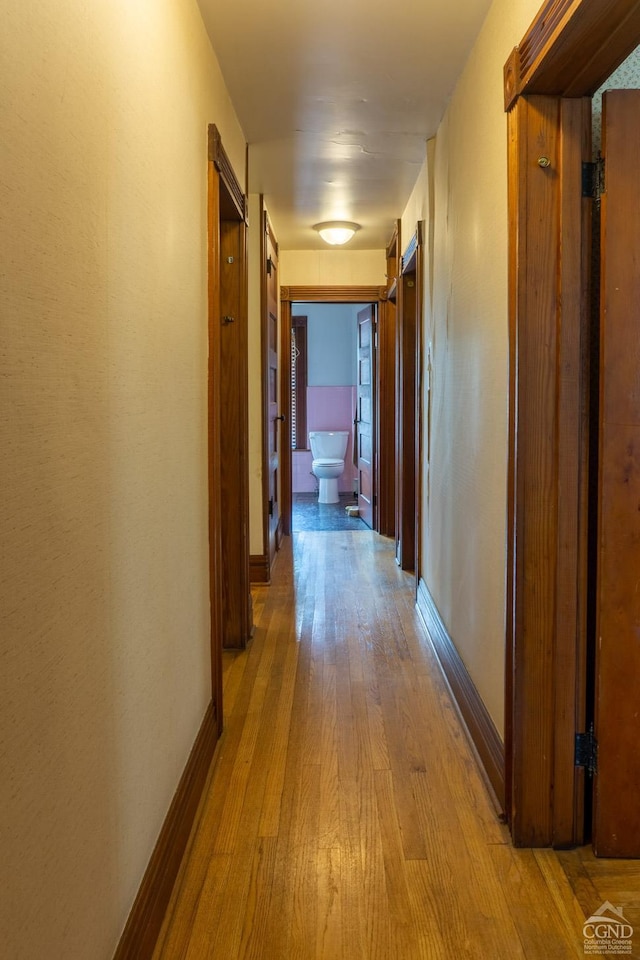 corridor with light hardwood / wood-style floors