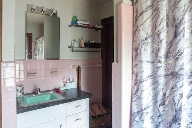 bathroom with vanity, curtained shower, and tile walls