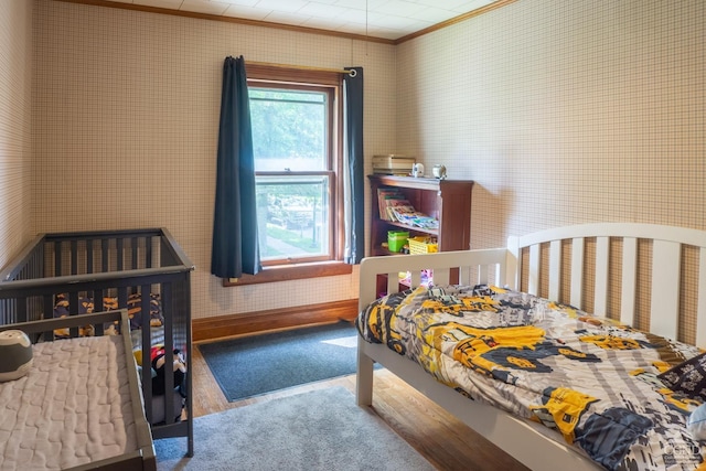 bedroom with wood-type flooring and crown molding