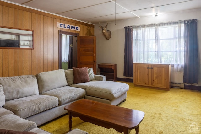 living room featuring light colored carpet, wooden walls, and a baseboard radiator