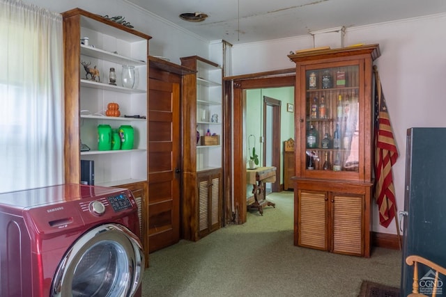 clothes washing area with washer / dryer, light colored carpet, and crown molding