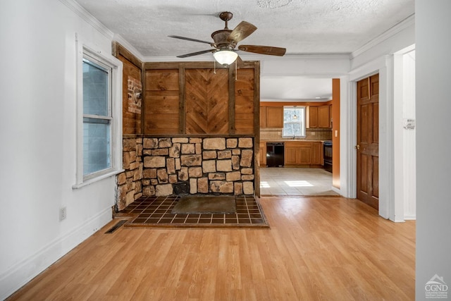 interior space with ceiling fan, crown molding, a textured ceiling, and light hardwood / wood-style flooring