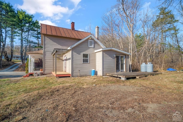 rear view of house featuring a lawn and a deck