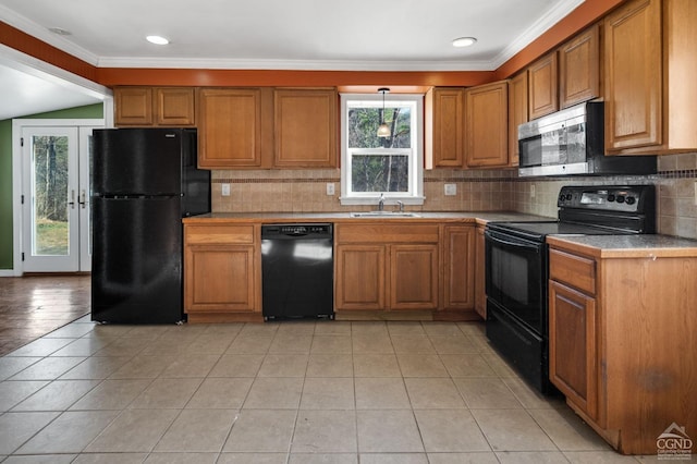 kitchen with decorative backsplash, crown molding, light tile patterned flooring, and black appliances