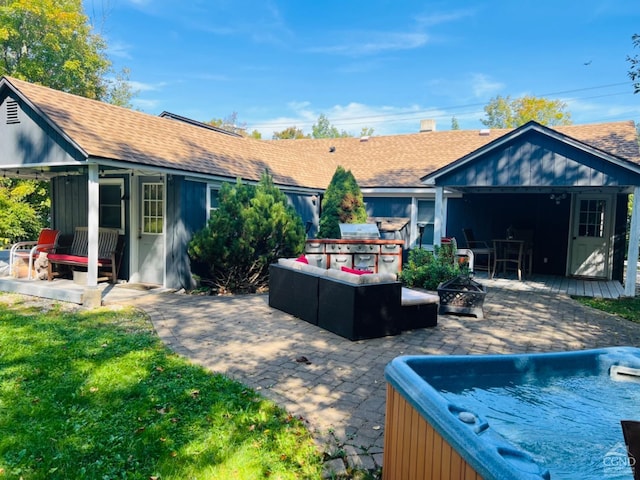 back of house featuring a patio and an outdoor living space with a fire pit