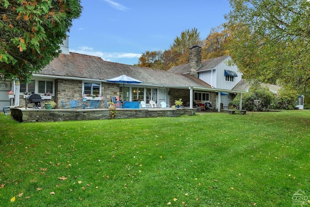 rear view of house featuring a yard and a patio