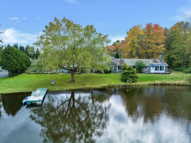 view of dock featuring a water view and a yard