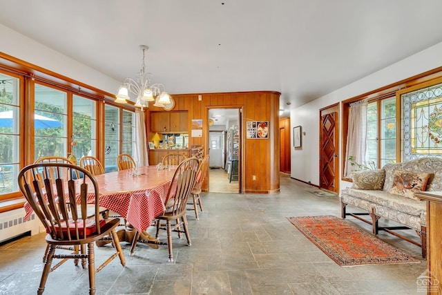 105 Gaf Lake Rd, Sanford, NY 13865 - dining room with radiator heating unit, an inviting chandelier, a healthy amount of sunlight, and wood walls