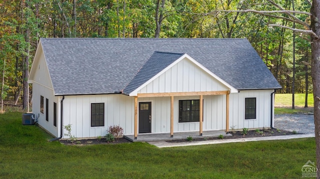 modern farmhouse style home featuring covered porch, central air condition unit, and a front lawn