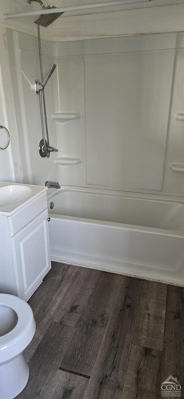 bathroom with wood finished floors, vanity, and tub / shower combination