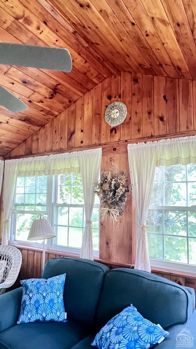 living room featuring wooden walls, ceiling fan, wood ceiling, and lofted ceiling