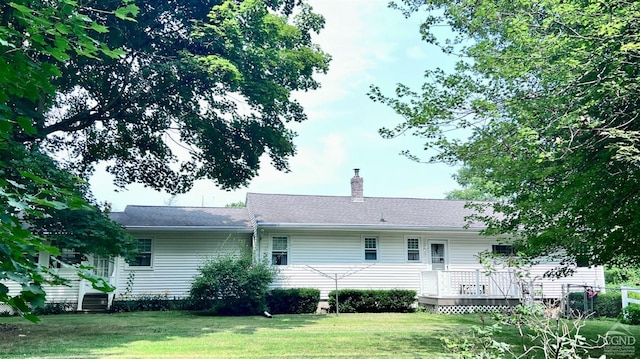 rear view of property featuring a yard and a wooden deck