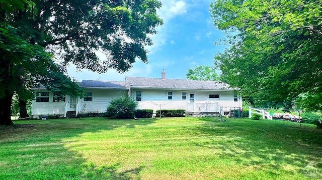 rear view of house with a deck and a lawn