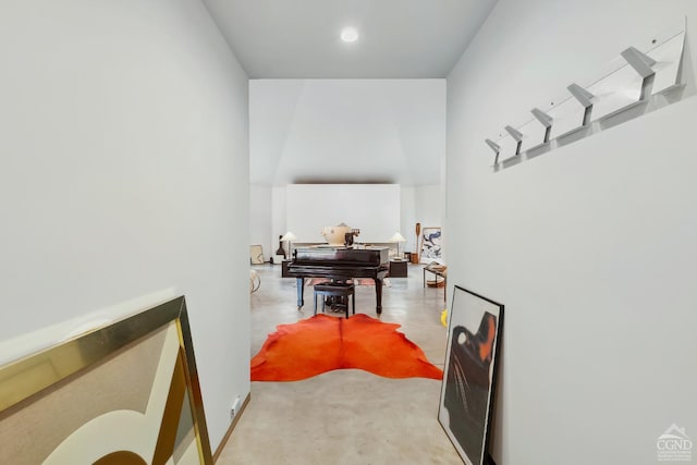 hall featuring finished concrete flooring and a towering ceiling