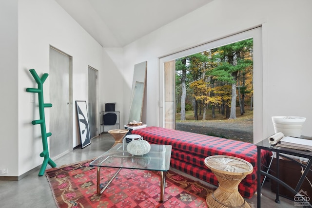 sitting room with baseboards and finished concrete floors