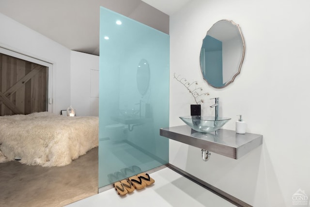 bathroom with a shower, recessed lighting, baseboards, and a sink