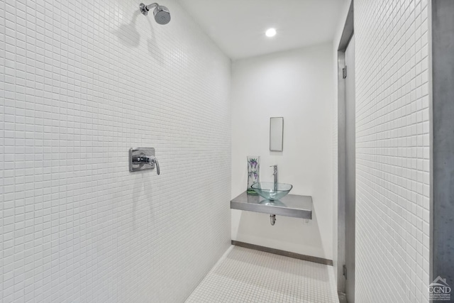 full bath with a sink, recessed lighting, tile patterned flooring, and tiled shower