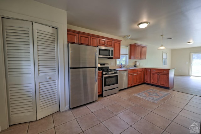 kitchen featuring hanging light fixtures, plenty of natural light, light tile patterned flooring, and stainless steel appliances