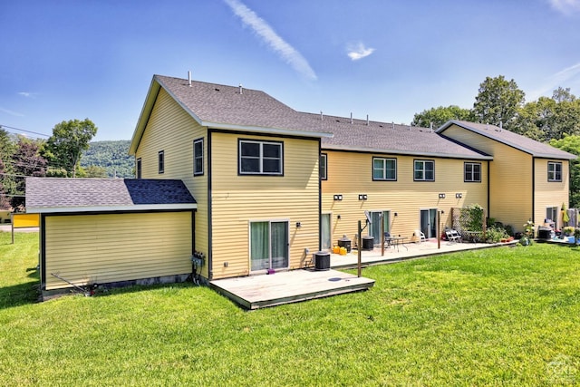 rear view of property with a yard, a patio, and central AC