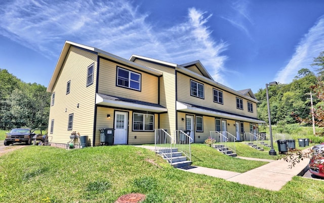 townhome / multi-family property with covered porch, central air condition unit, and a front lawn