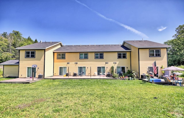 rear view of property featuring a patio area, a yard, and central AC