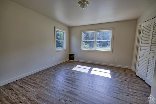 unfurnished bedroom featuring a closet and dark hardwood / wood-style floors