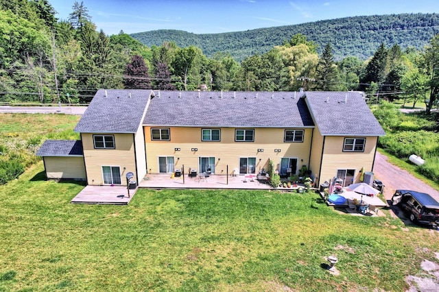 back of house featuring a yard and a deck with mountain view