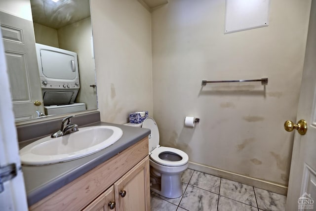 bathroom with vanity, toilet, and stacked washer / drying machine