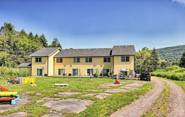 rear view of house featuring a yard