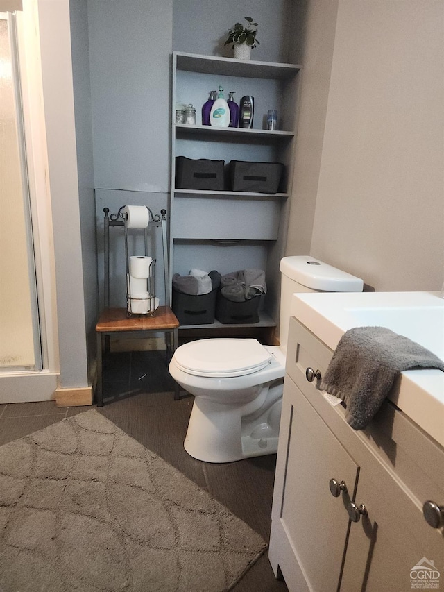 bathroom with vanity, toilet, and an enclosed shower