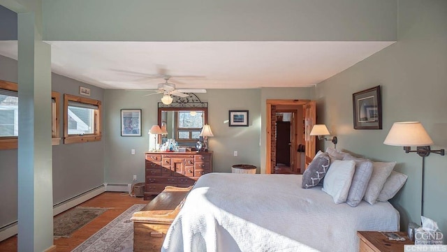 bedroom featuring hardwood / wood-style flooring, ceiling fan, and baseboard heating