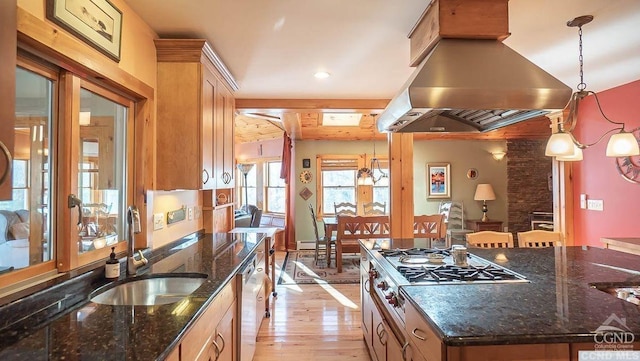 kitchen with island range hood, sink, light wood-type flooring, and hanging light fixtures