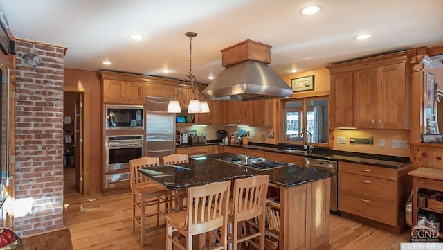 kitchen with pendant lighting, a center island, light hardwood / wood-style floors, and appliances with stainless steel finishes