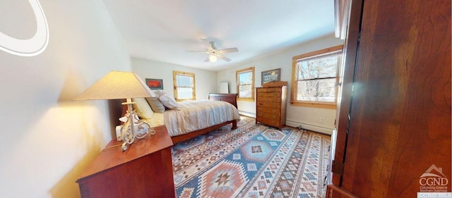 bedroom featuring ceiling fan and a baseboard heating unit