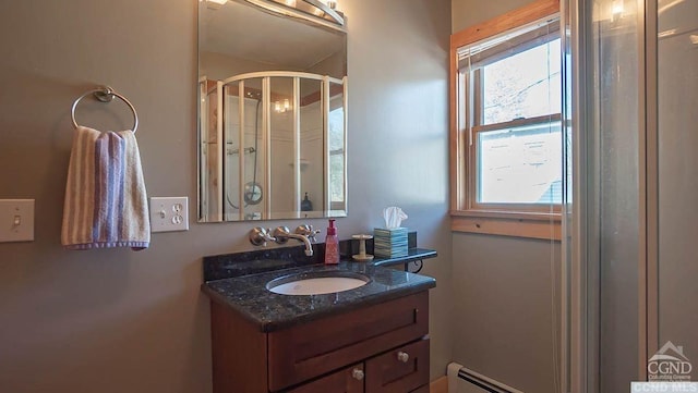 bathroom with vanity, baseboard heating, and a shower with shower door