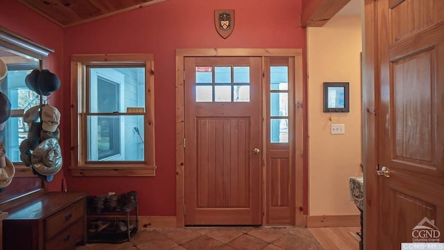 foyer entrance with light tile patterned flooring, lofted ceiling, and wood ceiling