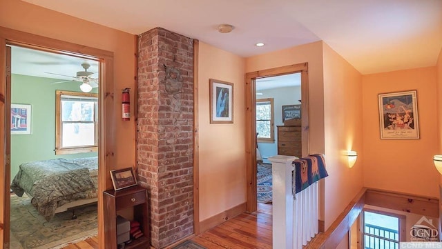 hallway featuring light wood-type flooring and a wealth of natural light