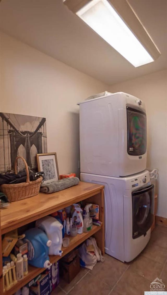 laundry room with light tile patterned flooring and stacked washing maching and dryer