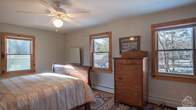 bedroom featuring wood-type flooring, a baseboard radiator, and ceiling fan